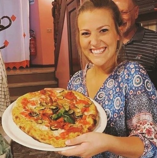 Tippie student holding pizza in Italy