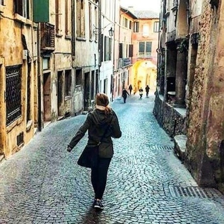 Student walking down a street in Italy