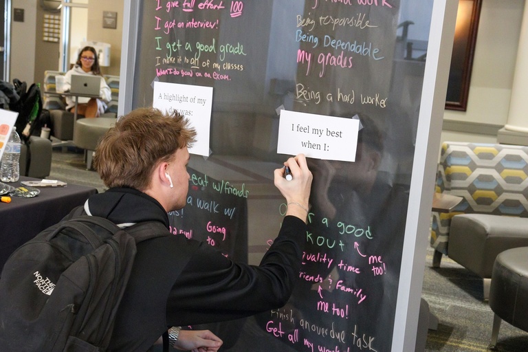 Student writing on a board.