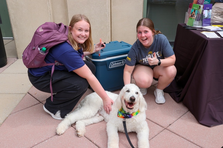 Students petting emotional support dog.