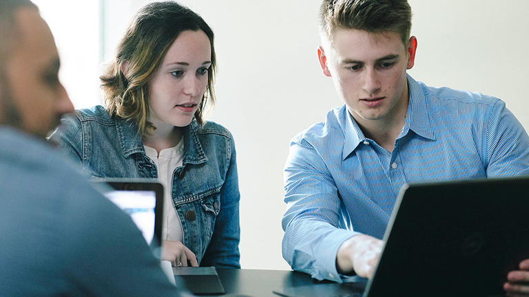 Two students looking at a laptop